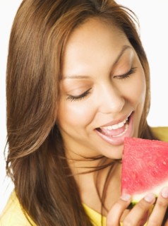 Close up of Hispanic woman eating watermelon