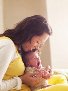 Mother holding newborn baby in her lap