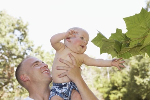 Father holding baby outdoors