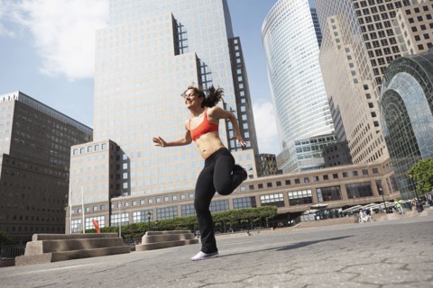 Mixed race woman working out on city street