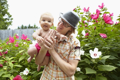 Father carrying baby daughter in park