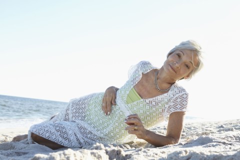 Senior woman laying on tropical beach