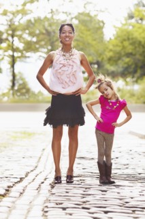 Mother and daughter posing on city street