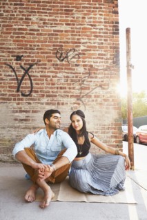 Indian couple sitting on city street