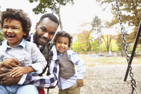 Father and sons playing together in park