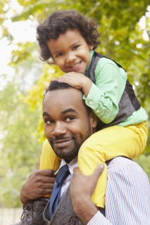 Father carrying son in park