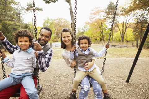 Family sitting on swings in park