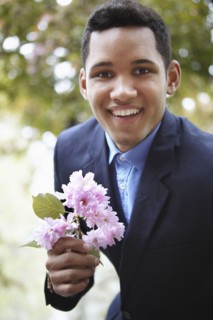 Smiling man in suit holding flower