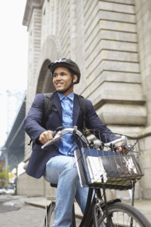 Smiling man riding bicycle on city street
