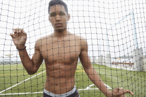Man standing in soccer net on field