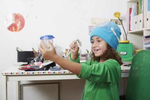 Mixed race girl doing science experiments at desk