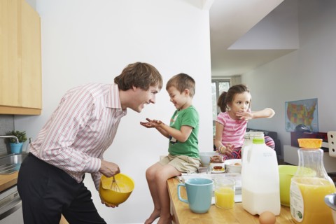 Father making breakfast for children in kitchen