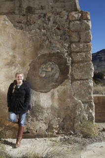 Tourist smiling near relief sculpture on wall of ruins