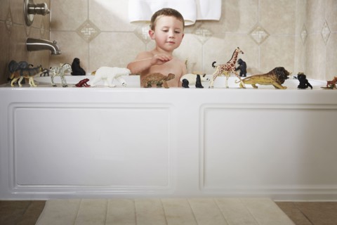 Caucasian boy playing in bathtub