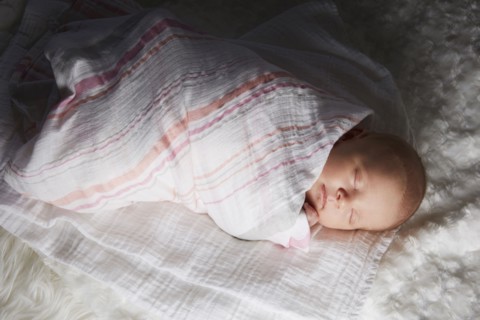 Newborn baby swaddled in blanket