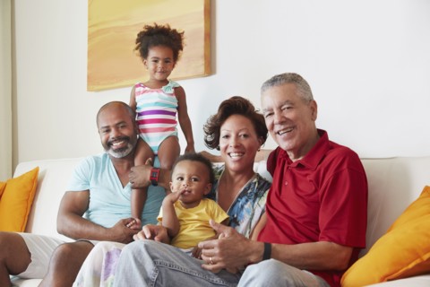 Multi-generation family smiling on sofa