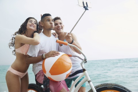 Smiling friends taking selfie on beach
