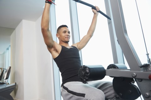 Black man using exercise machine in gym