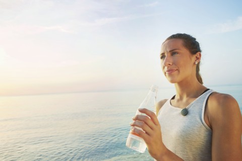 Athlete drinking water bottle on beach