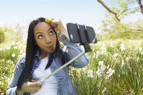 Black woman taking self portrait in park