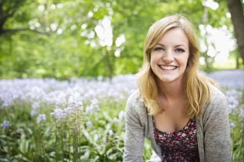 Caucasian woman smiling in field of flowers