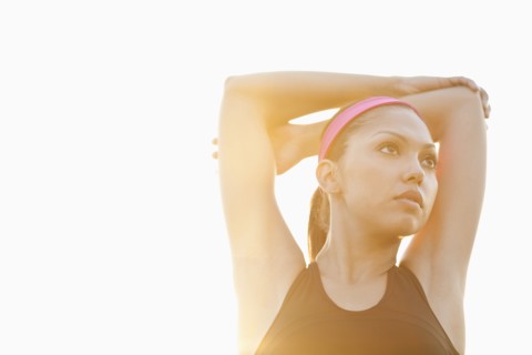 Hispanic woman stretching outdoors
