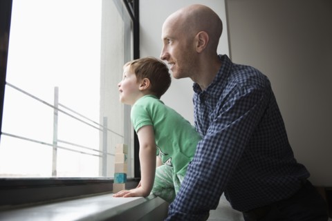 Father and son looking out window