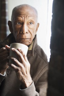 Older Black man drinking cup of coffee