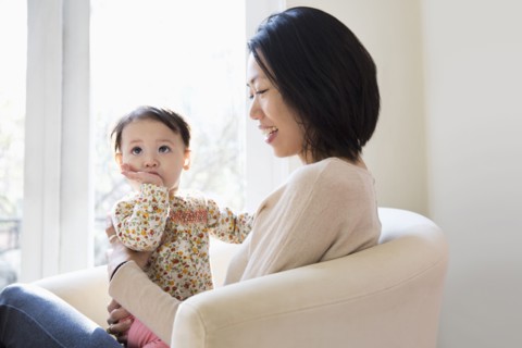 Mother and daughter hugging on sofa