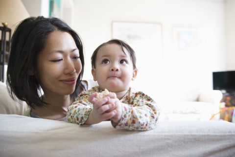 Mother and daughter sitting on sofa