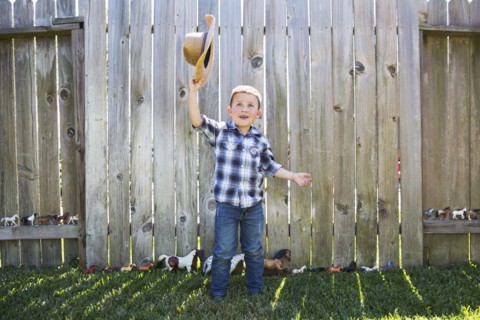 Caucasian boy waving cowboy hat