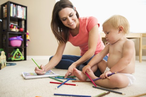 Caucasian mother and baby girl using colored pencils