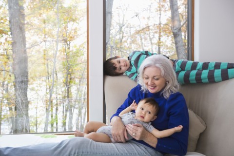 Smiling grandmother and grandsons near window