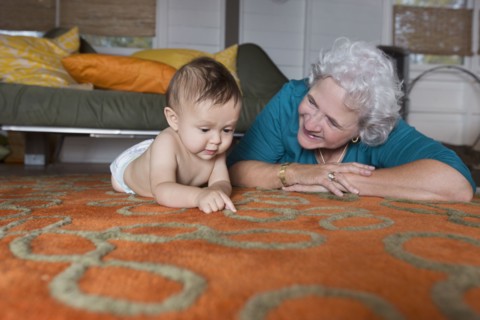 Grandmother and grandson laying on carpet