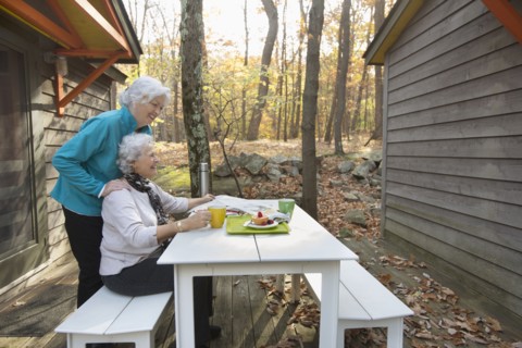 Caucasian women enjoying breakfast outdoors near cabin