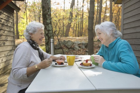 Caucasian women enjoying breakfast outdoors near cabin