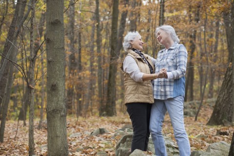 Caucasian women dancing outdoors in autumn