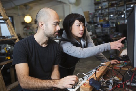 Man and woman working with electronics in workshop