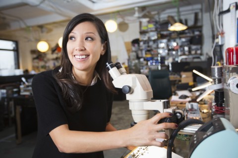 Mixed Race woman using microscope