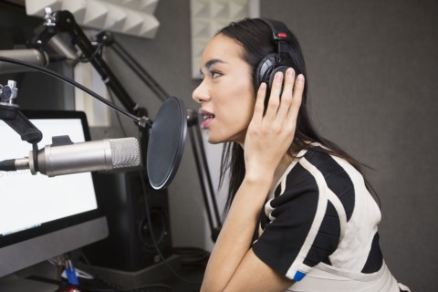 Thai transgender woman using headphones and microphone