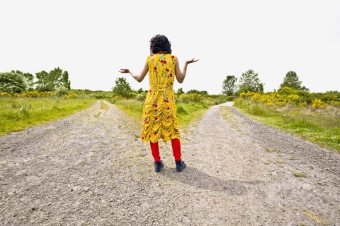 Asian woman shrugging at split in road