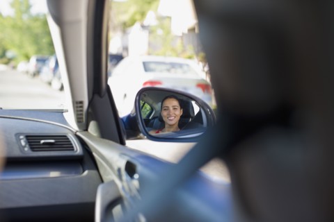 Image of Hispanic woman in car's side mirror