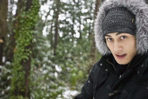 Mixed race man outdoors in hooded coat
