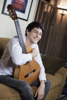 Mixed race man holding guitar
