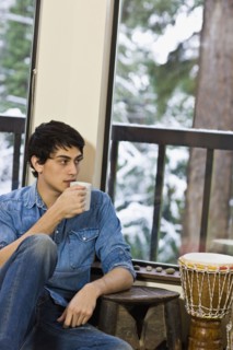 Mixed race man drinking coffee in living room