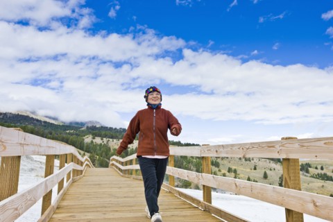 Japanese woman walking across wooden bridge