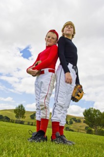 Baseball players standing back to back in field