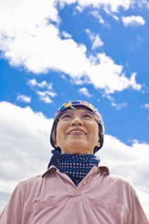 Older Japanese woman smiling outdoors