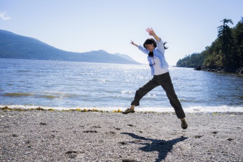 Japanese woman doing cartwheel on beach
