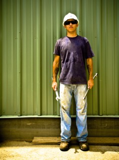 Caucasian construction worker holding wrenches on work site